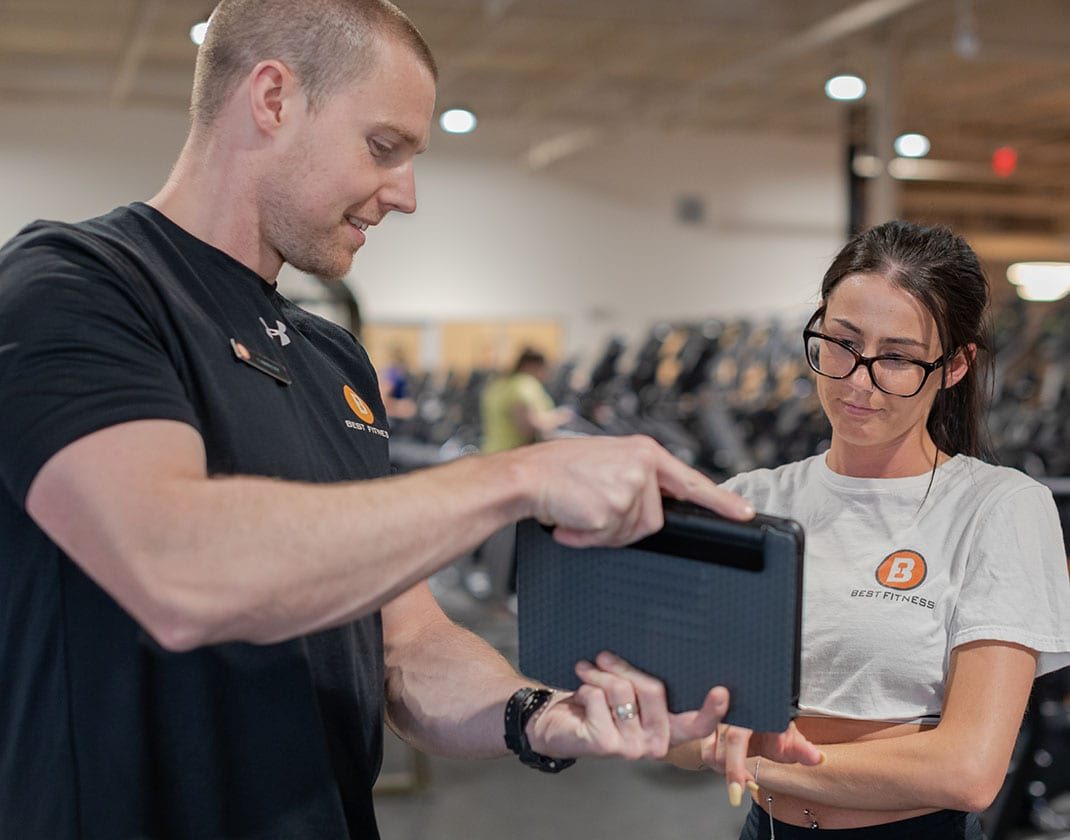 personal trainer showing results to gym member