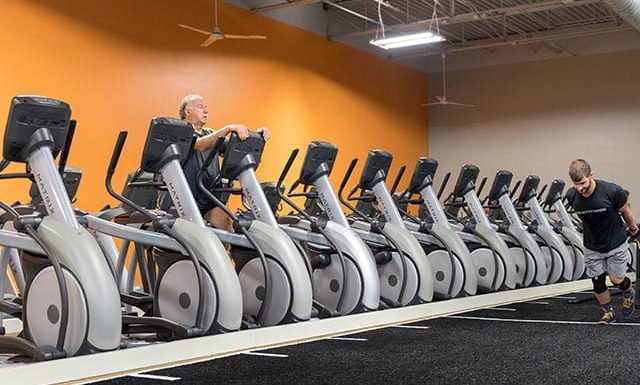 man using cardio machine in fitness studio area