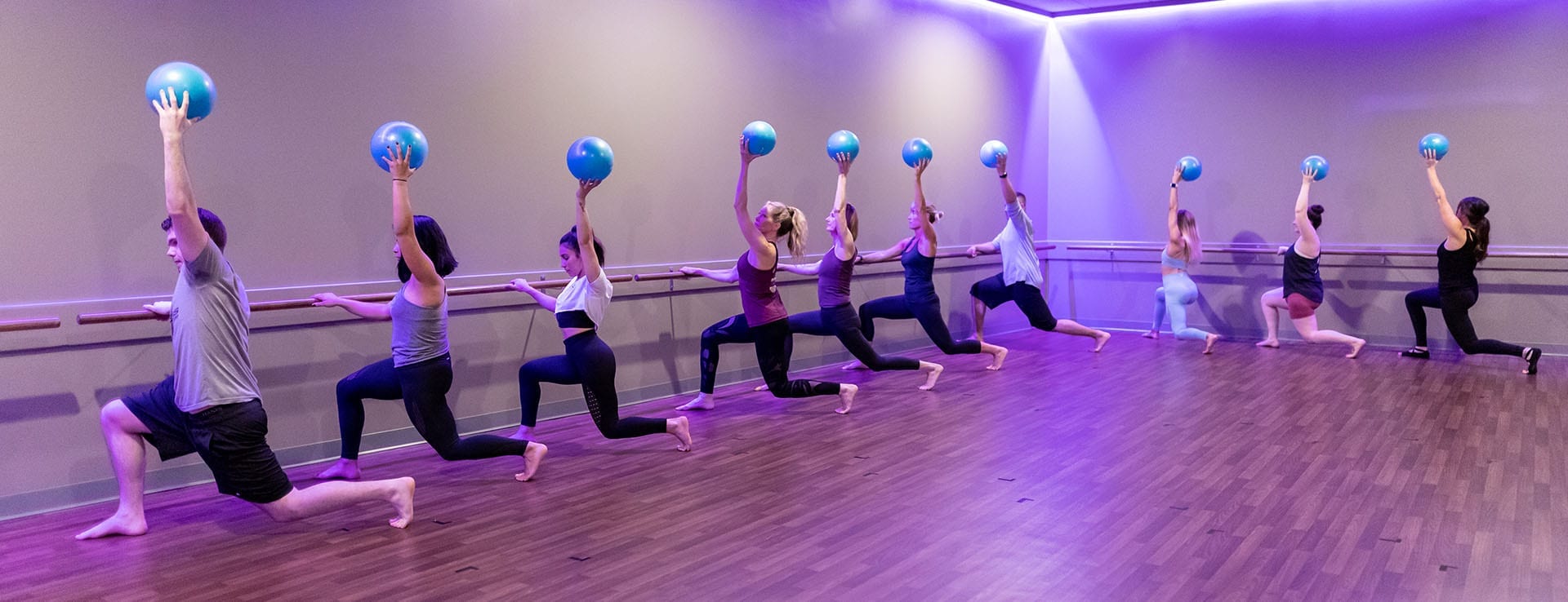 barre fitness class in spacious studio at modern gym