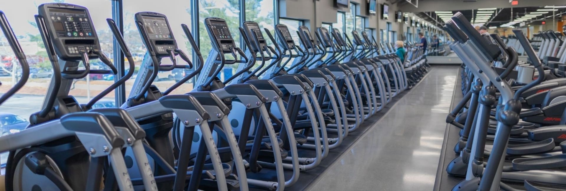 a row of elliptical cardio machines at best fitness gym near me in drum hill