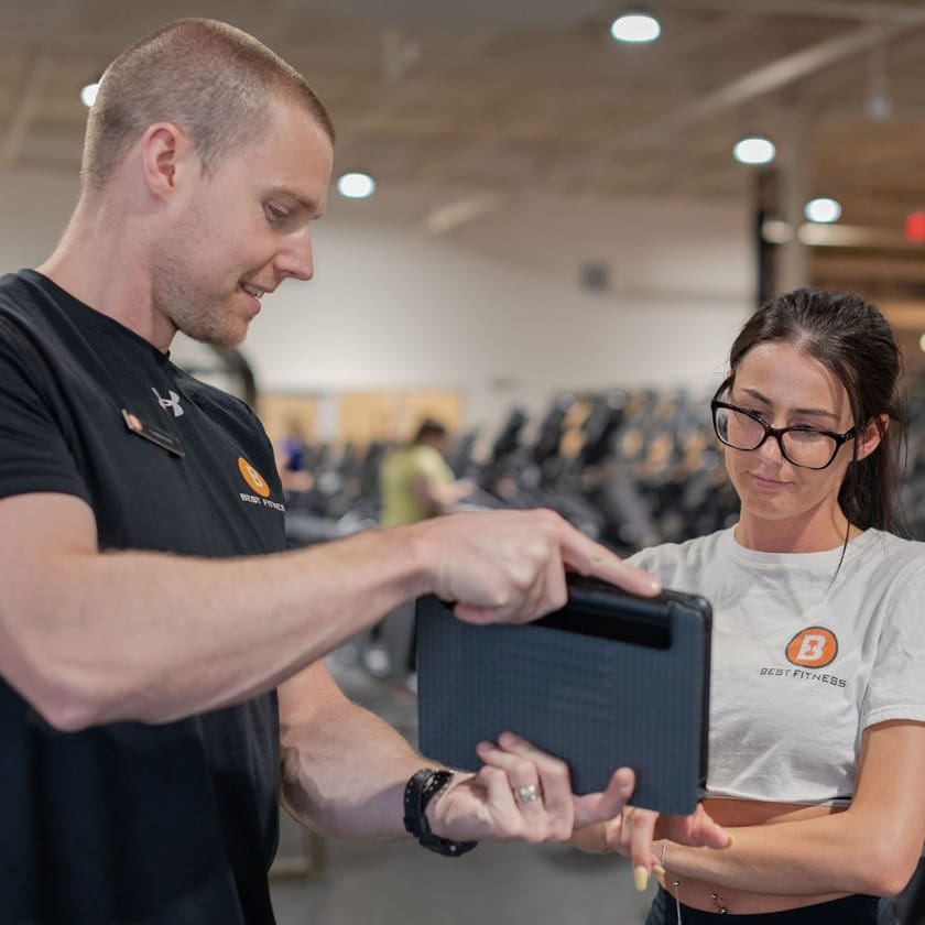 a gym member discusses a personalized training plan with a trainer at best fitness drum hill