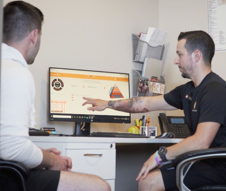 a personal trainer at best fitness gym in lowell helps a gym member with a personalized fitness plan
