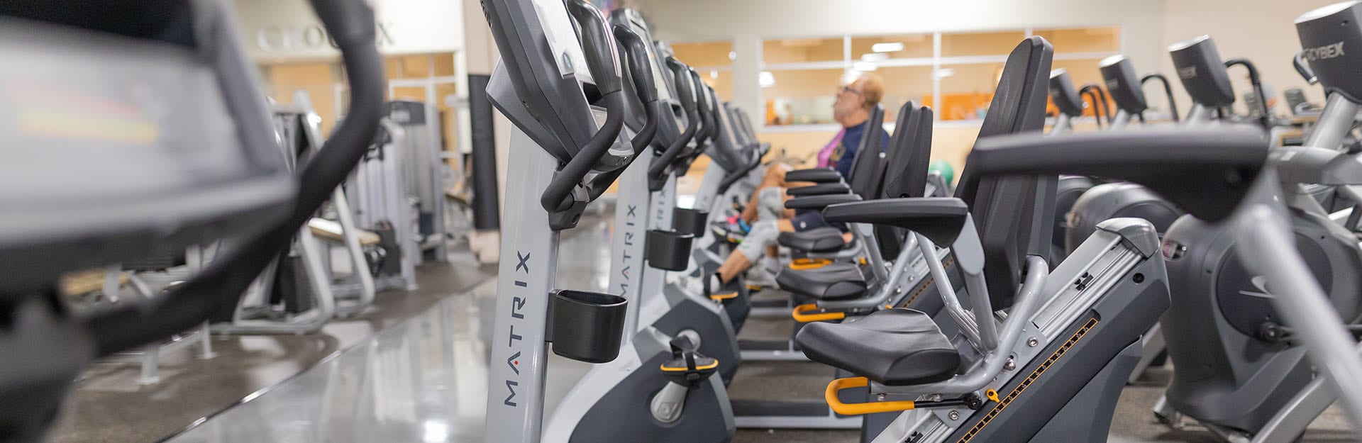 row of cardio equipment at modern gym