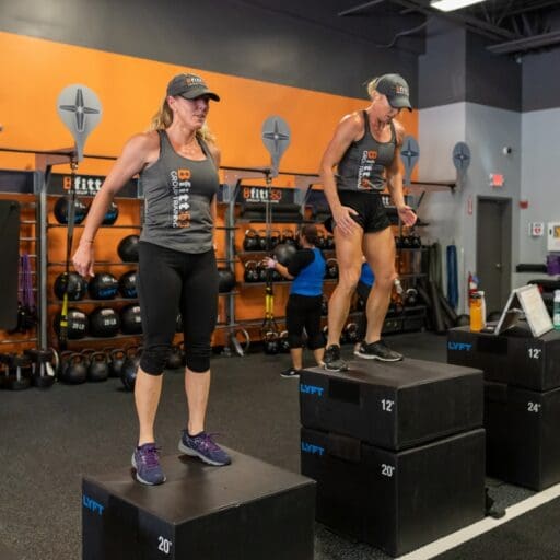 gym members do box jumps during a bfitt60 group fitness class at best fitness nashua