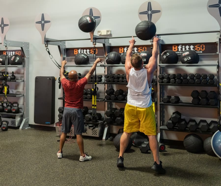 gym member use weighted balls during a small group training workout at best fitness in schenectady
