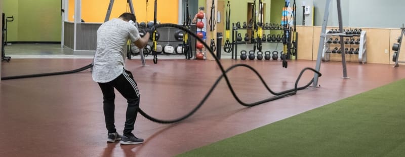 a gym member uses weighted ropes during a strength training workout at a gym near me in schenectady