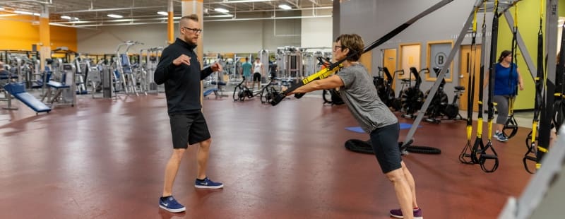 a gym member works with a personal trainer at best fitness gym in schenectady