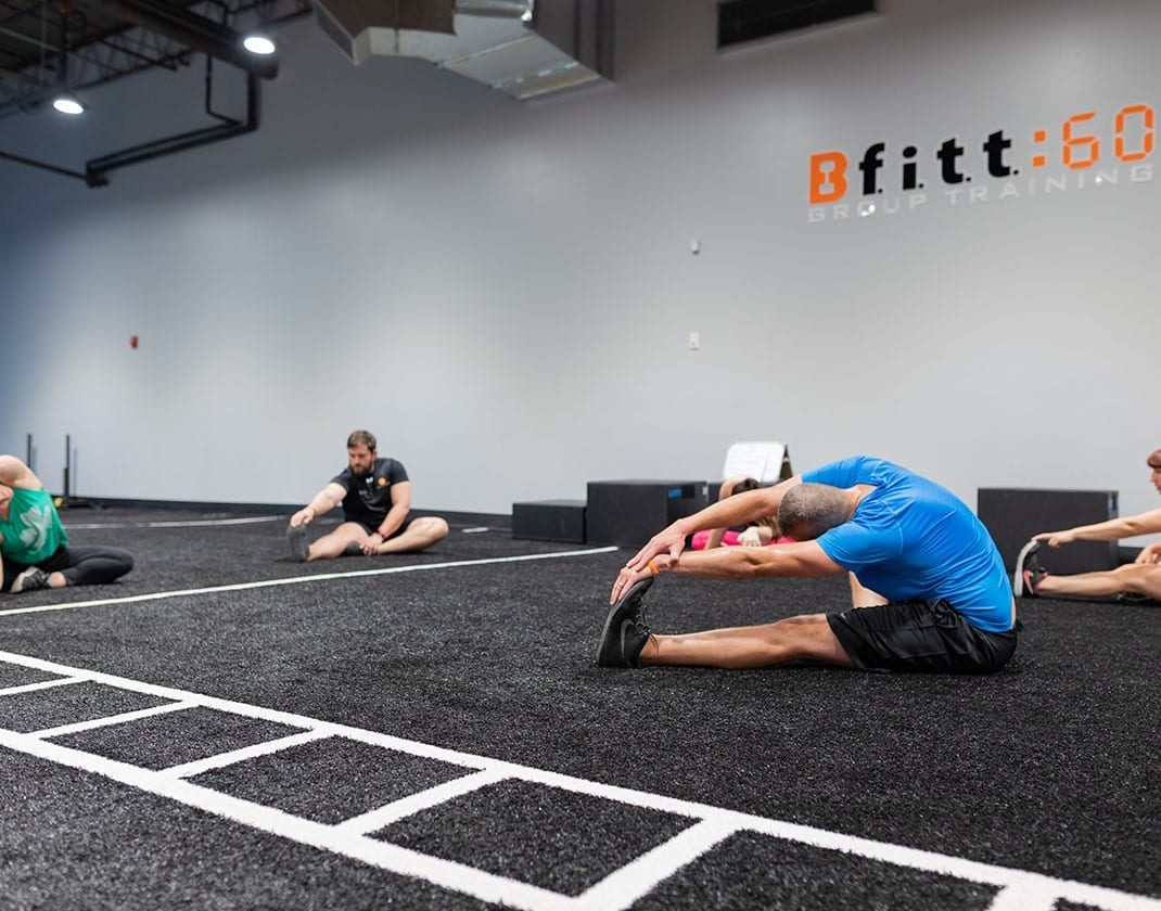 group of people stretching in spacious fitness studio
