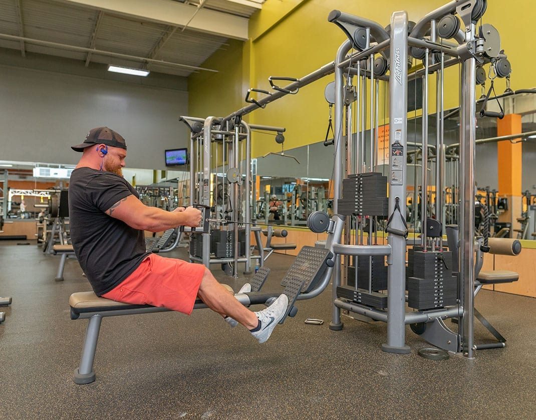man lifting weights on strength training machine