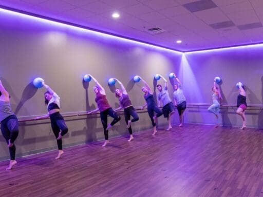 gym members do a barre pose during a group fitness class at best fitness gym in woburn