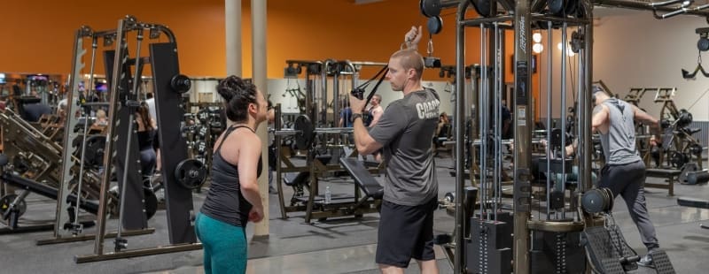 a gym member and personal trainer work on form during a personal training session at best fitness gym in woburn ma