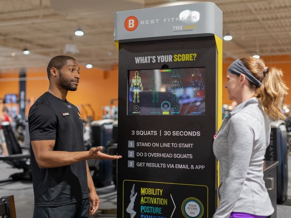 a personal trainer talks with a gym member during a personal training session at best fitness gym near me in woburn