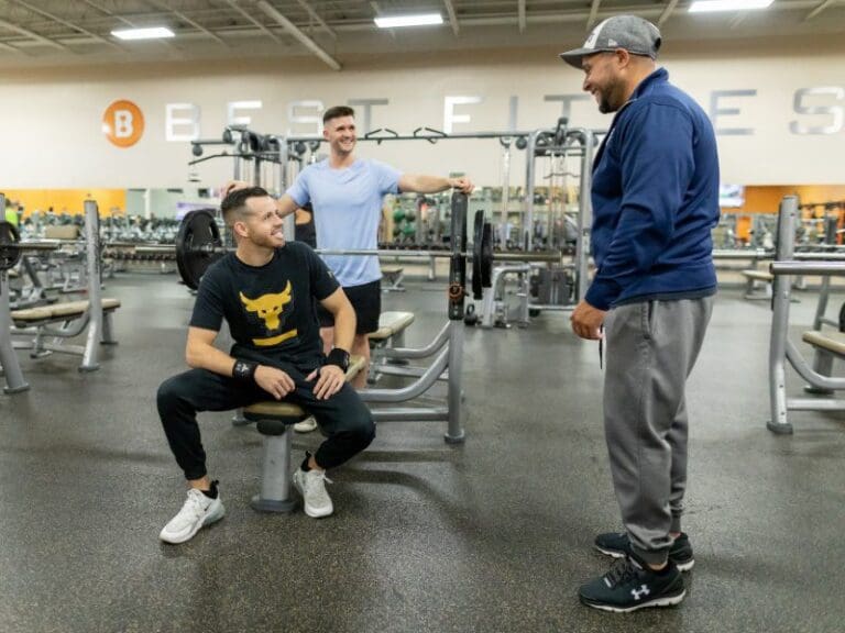 members and certified personal trainers chat between sets during a strength training workout at a best fitness gym near me
